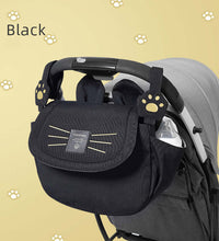 black stroller hanging baby bag attached to stroller handles, ideal for organizing baby essentials during walks or travel.