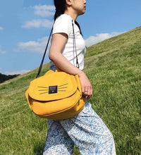 Yellow stroller hanging baby bag with multiple pockets, securely attached to stroller handles for convenient on-the-go storage.