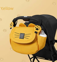 Yellow stroller hanging baby bag attached to stroller handles, ideal for organizing baby essentials during walks or travel.