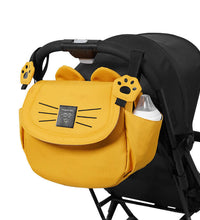 Yellow stroller hanging baby bag attached to stroller handles, ideal for organizing baby essentials during walks or travel.